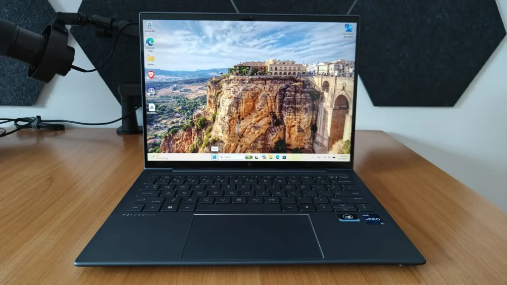 HP Elite Dragonfly G3 business laptop with a 13.5-inch touchscreen displaying the Windows 11 desktop and a colorful landscape wallpaper.