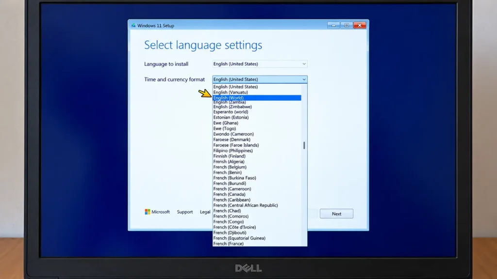 Windows 11 setup showing English (World) highlighted in the Time and currency format dropdown